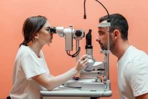 optometrist looking into mans eyes